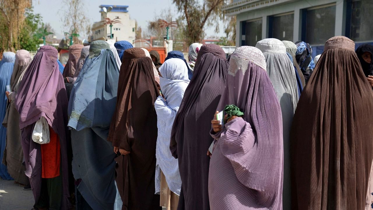 Afghan women stand on a queue to receive food aid distributed by a charity foundation during the Muslim holy fasting month of Ramadan. Credit: AFP Photo