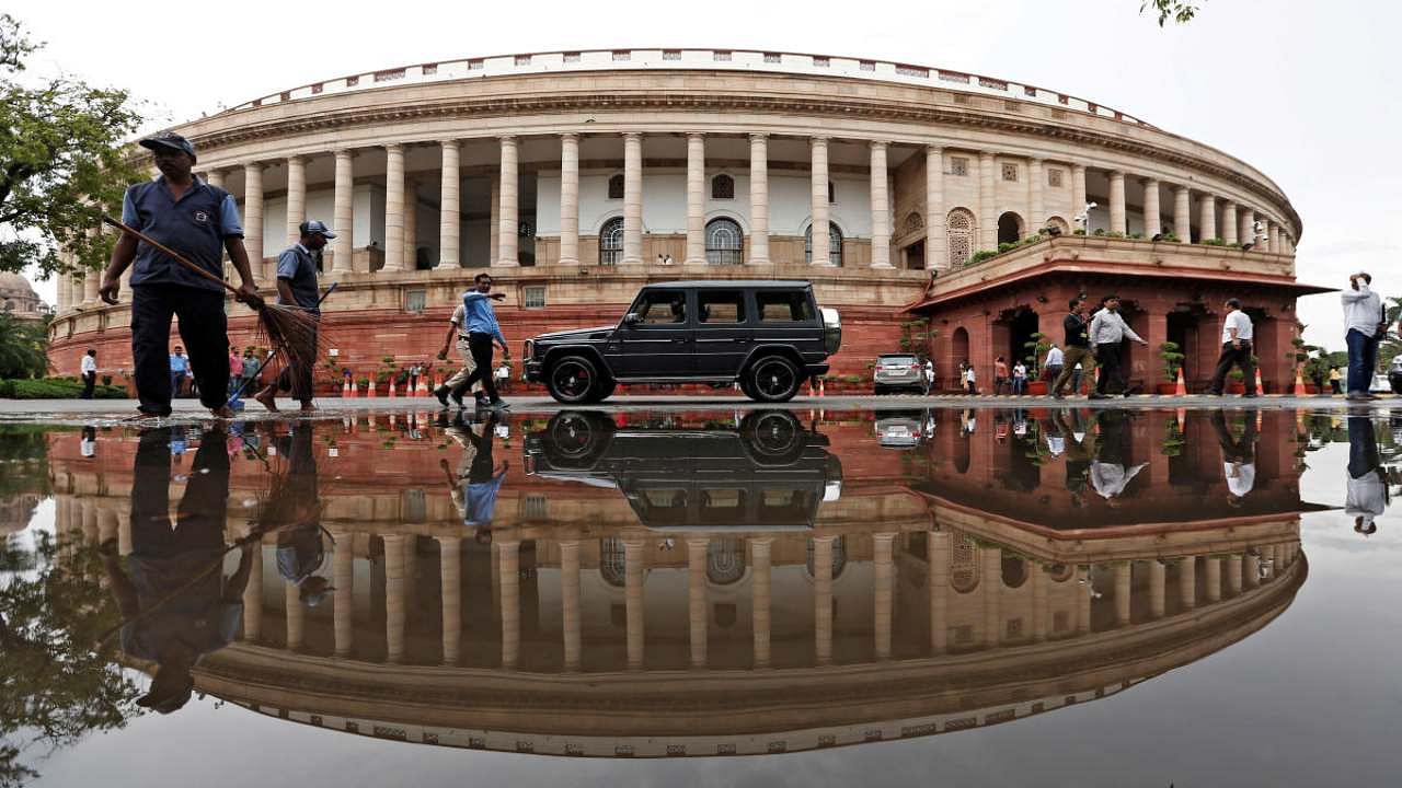 Parliament building is reflected in a puddle after the rain in New Delhi. Photo credit: Reuters