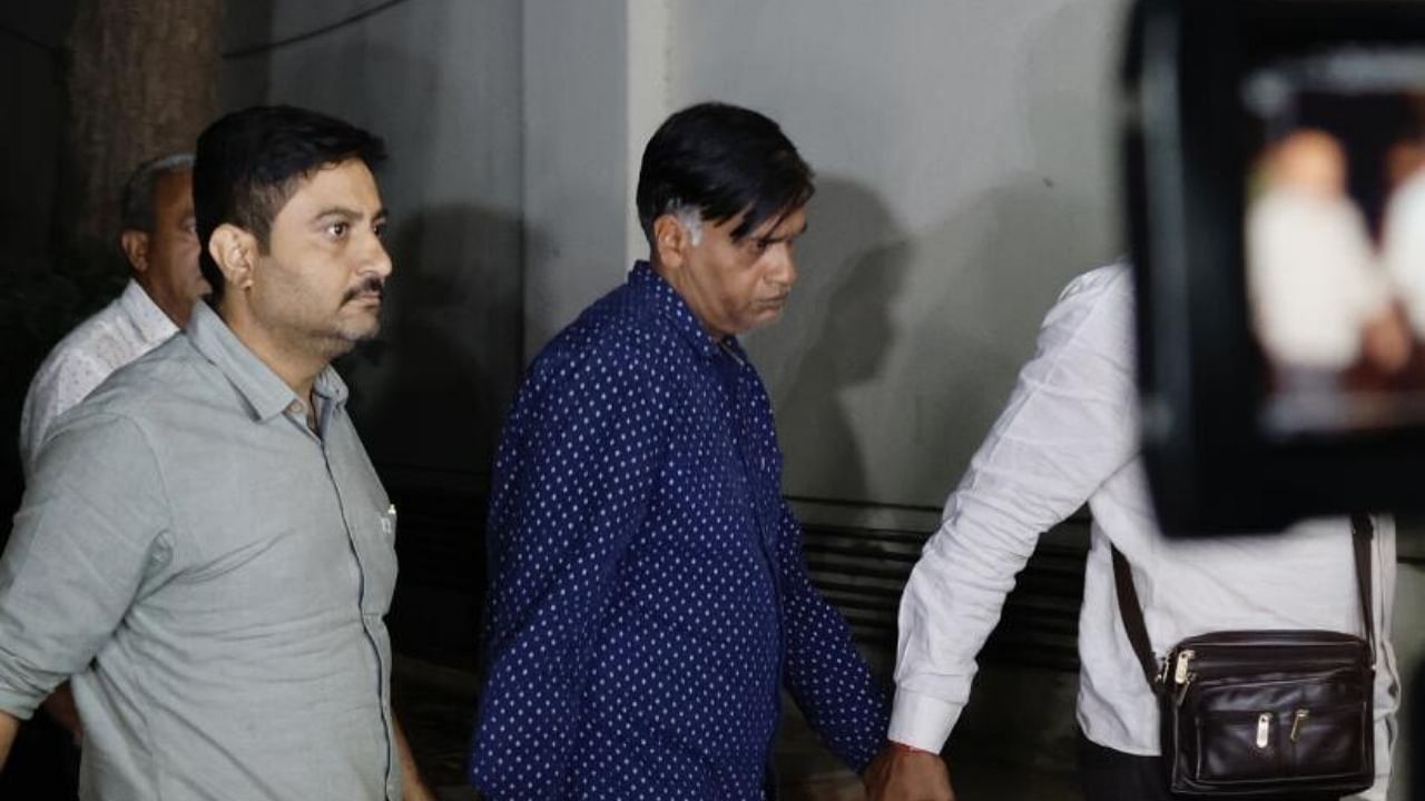 Kiran Patel (R), accused of cheating, forgery and impersonation as PMO official, being brought from Srinagar by crime branch officials, at Crime Branch office in Ahmedabad. Credit: PTI Photo