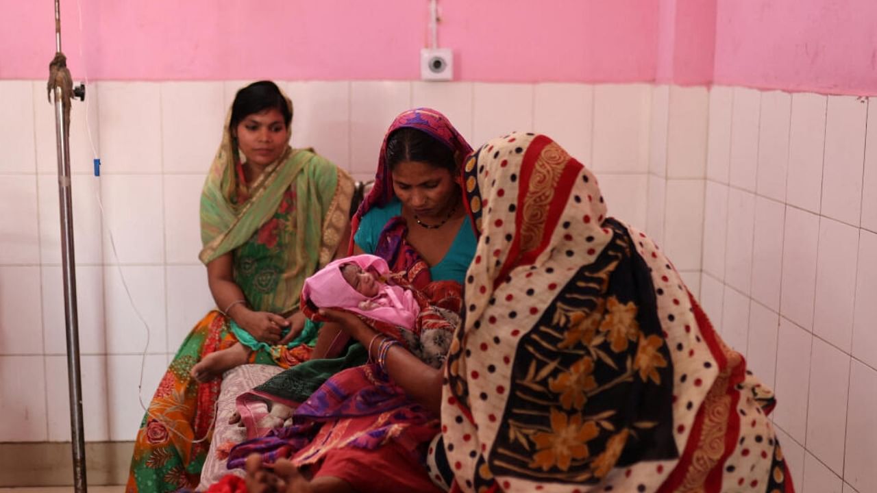 Zamerun Nisha, 33, holds her newborn baby as her sister Sanerum, 38, and her sister-in-law Zabinad, 15, keep her company at the maternity ward of a community health centre in Bahadurganj subdivision of Kishanganj district in Bihar. Credit: Reuters Photo