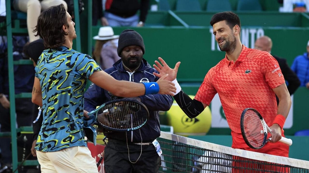 Serbia's Novak Djokovic (R) and Italy's Lorenzo Musetti (L) shake hands after their Monte-Carlo ATP Masters Series tournament round of 16 tennis match in Monte Carlo on April 13, 2023. Credit: AFP Photo