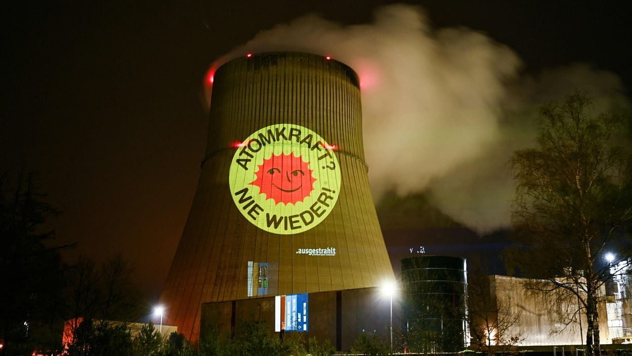 Activists of the nationwide anti-nuclear organisation 'Ausgestrahlt' illuminate a cooling tower of the nuclear power plant Emsland run by German energy company RWE with the slogan 'Nuclear energy - never again' in Lingen, western Germany on April 10, 2023. Credit: AFP Photo