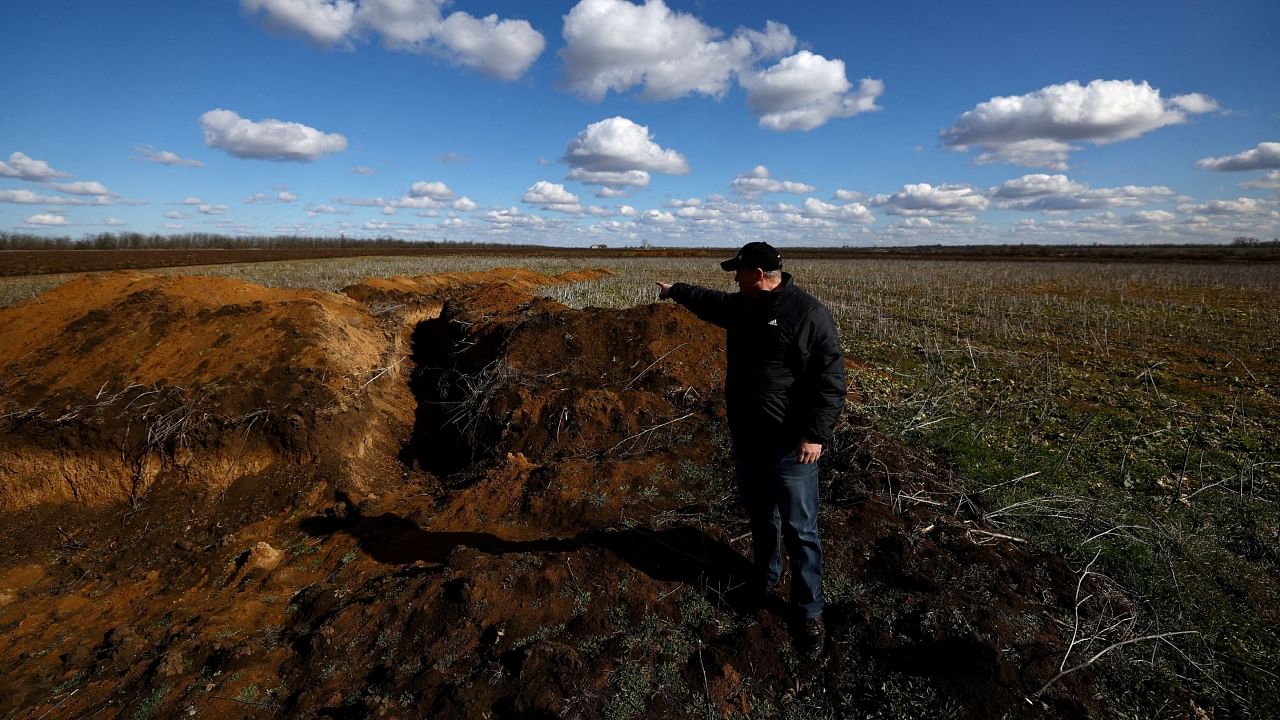 Grain farmer Oleksandr Klepach points at trenches in his field, amid Russia's invasion of Ukraine, in Snihurivka, southeast Ukraine, February 20, 2023. Credit: Reuters File Photo