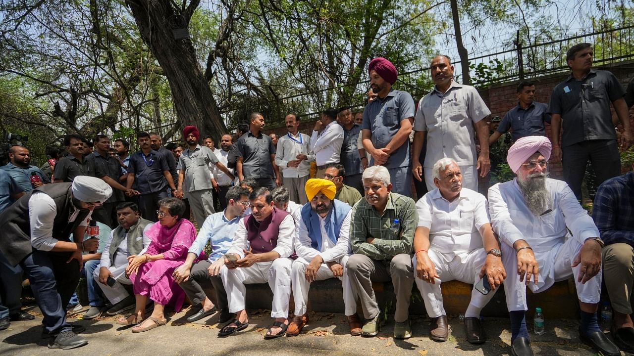 Punjab CM Bhagwant Mann, AAP MP Sanjay Singh and party leaders sit in support of Delhi CM Arvind Kejriwal while he was appearing before the CBI officials for questioning in connection with the Delhi liquor policy case. Credit: PTI Photo