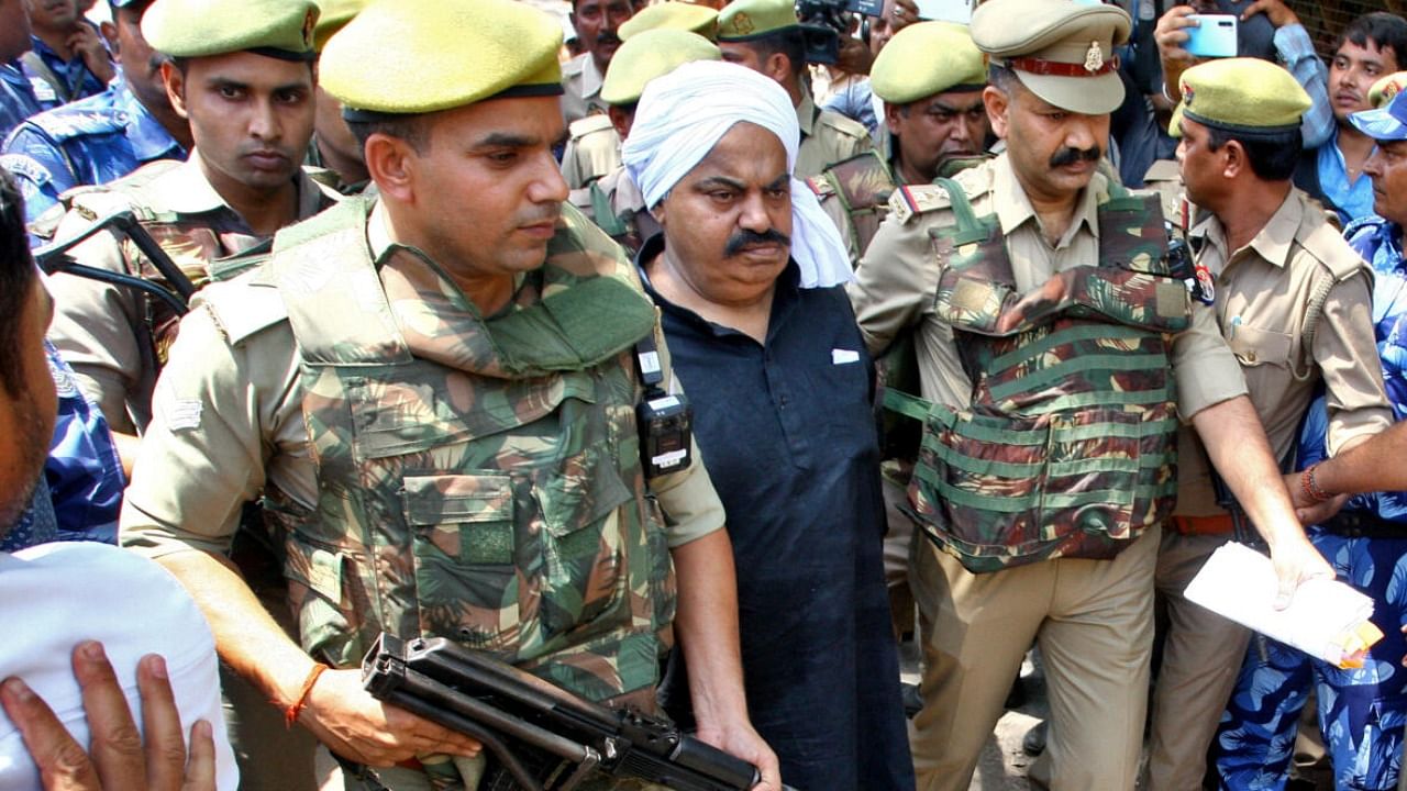 File photo of police officers escorting Atiq Ahmed to a court in UP. Credit: PTI Photo