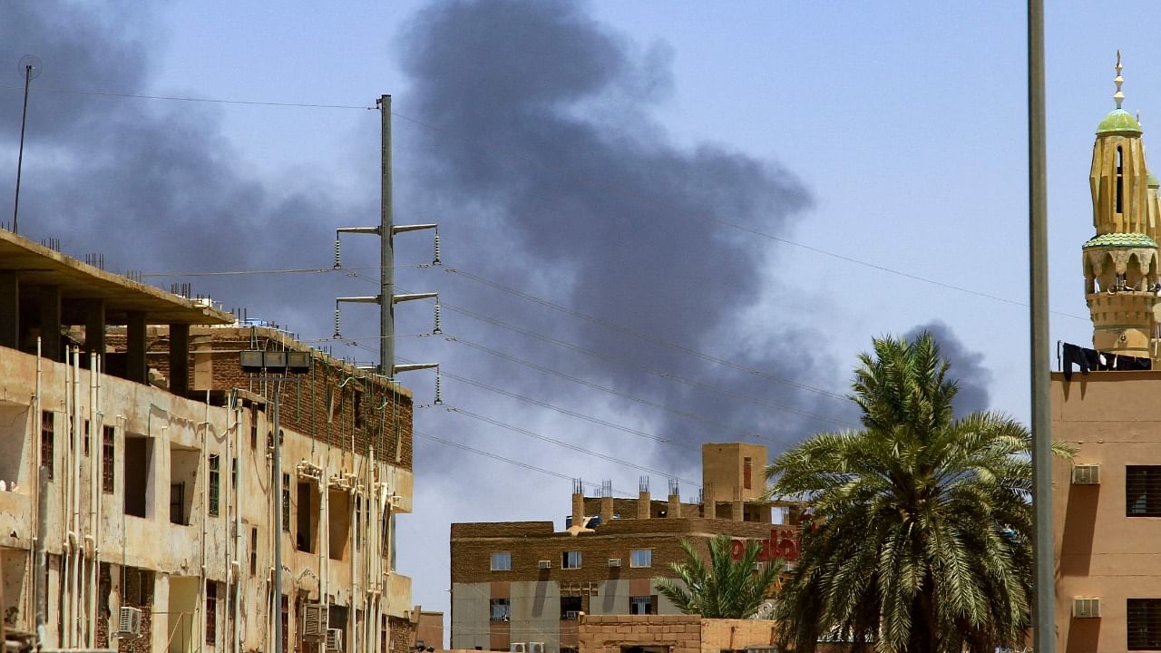 Smoke rises behind buildings in Khartoum on April 19, 2023, as fighting between the army and paramilitaries raged for a fifth day after a 24-hour truce collapsed. Credit: AFP Photo