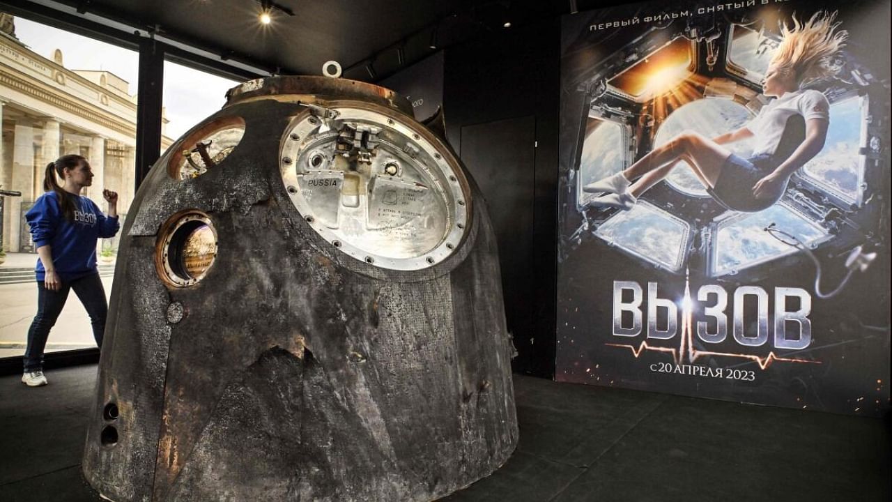 A woman walks next to the Russian Soyuz MS-18 space capsule which brought back to the Earth on October 17, 2021 Russian actress Yulia Peresild, in Moscow on April 18, 2023. - The Russian actress and film director spent 12 days on the International Space Station (ISS) shooting scenes for the first movie made in Space. Credit: AFP Photo