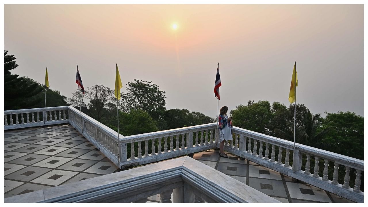 A visitor looks out at high levels of air pollution from the top of Doi Suthep temple in Chiang Mai. Credit: AFP Photo