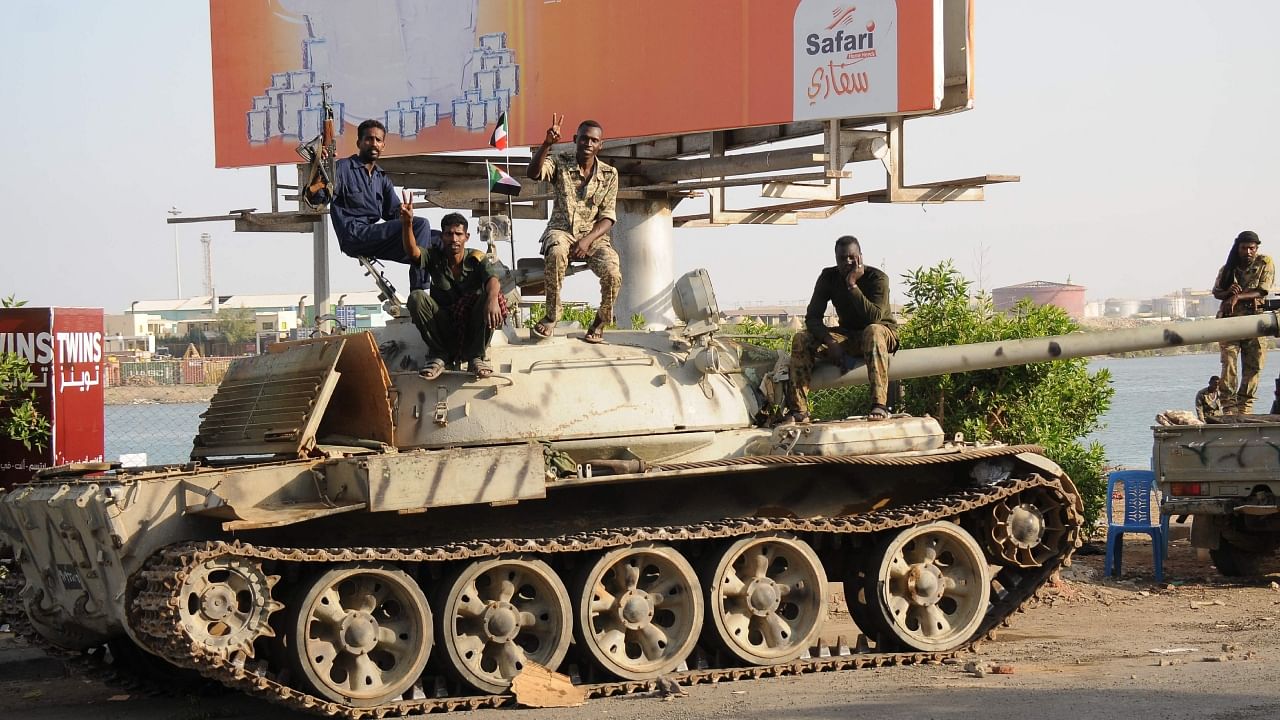 Sudanese army soldiers, loyal to army chief Abdel Fattah al-Burhan, sit atop a tank in the Red Sea city of Port Sudan, on April 20, 2023. - More than 300 people have been killed since the fighting erupted April 15 between forces loyal to al-Burhan and his deputy, Mohamed Hamdan Daglo, who commands the paramilitary Rapid Support Forces (RSF). Credit: AFP Photo