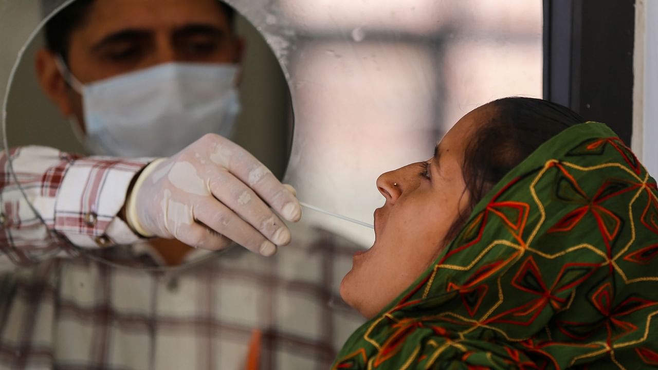  A healthcare worker collects a swab sample of a woman for Covid-19 test, amid a rise in coronavirus cases in the country, in Jammu, Saturday, April 15, 2023. Credit: PTI Photo