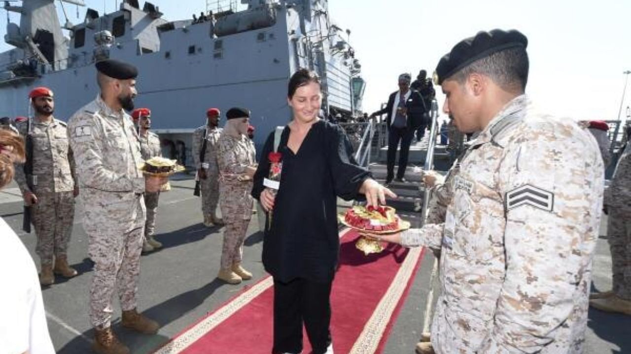 Evacuee being offered sweets upon arrival in the UAE. Credit: AFP Photo/Ho/Spa