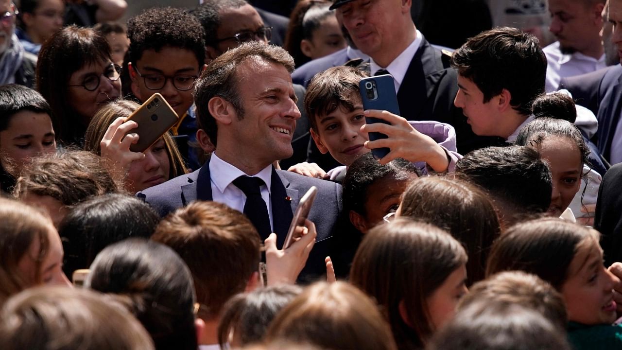 French President Emmanuel Macron poses for a selfie with school children as he visits a middle school, in Ganges, southern France, on April 20, 2023. The 45-year-old French President has been encouraged by allies to get out and meet voters after signing his unpopular pensions reform into law following months of protests, with some fearing he was becoming too reclusive inside the presidential palace. Credit: AFP Photo