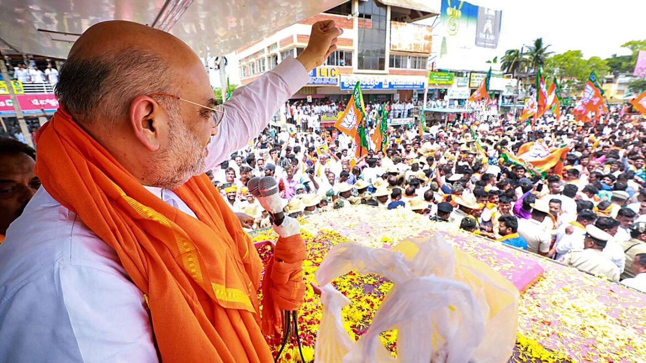  Union Home Minister and BJP leader Amit Shah waves at supporters during a roadshow in Karnataka's Gundlupet. Credit: PTI Photo