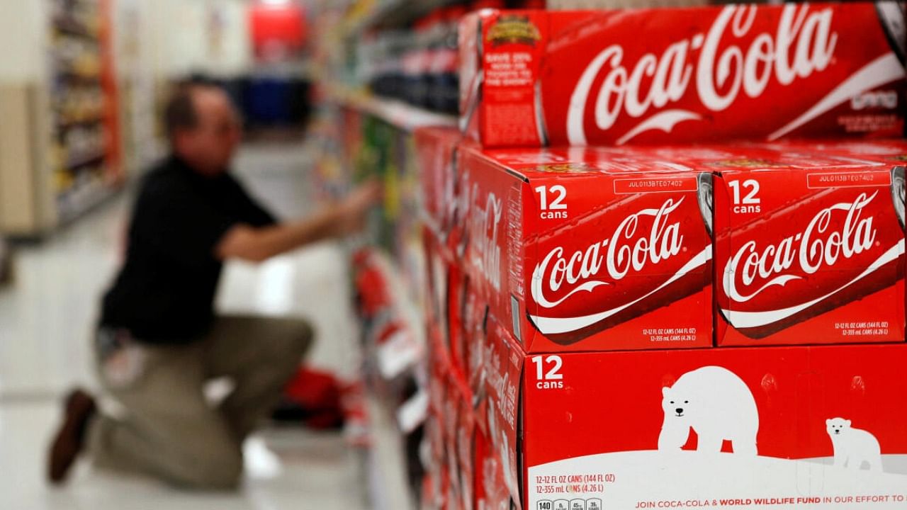 An employee arranges bottles of Coca-Cola at a store. Credit: Reuters Photo