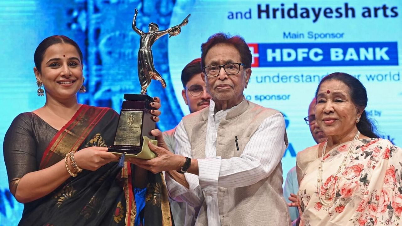 Bollywood actress Vidya Balan (L) receives the Lata Deenanath Mangeshkar Puraskar from music composer and singer Hridaynath Mangeshkar (C) as playback singer Asha Bhosle watches during an annual award ceremony in Mumbai. Credit: AFP Photo