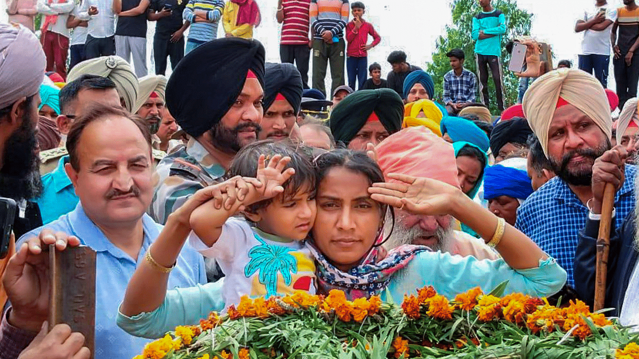 Wife and daughter of Sepoy Harkrishan Singh, who was killed in Poonch's terror attack, salute his mortal remains, in Batala. Credit: PTI Photo