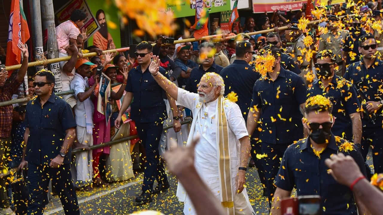 Prime Minister Narendra Modi waves at supporters during a roadshow, in Kochi. Credit: PTI Photo