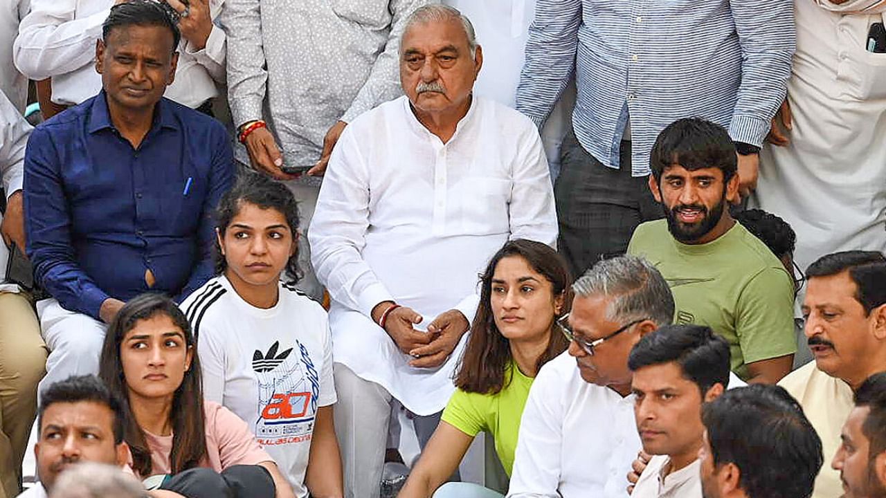 Congress leader Bhupinder Singh Hooda with wrestlers Vinesh Phogat, Sakshi Malik, Bajrang Punia and others during their protest at Jantar Mantar. Credit: PTI Photo