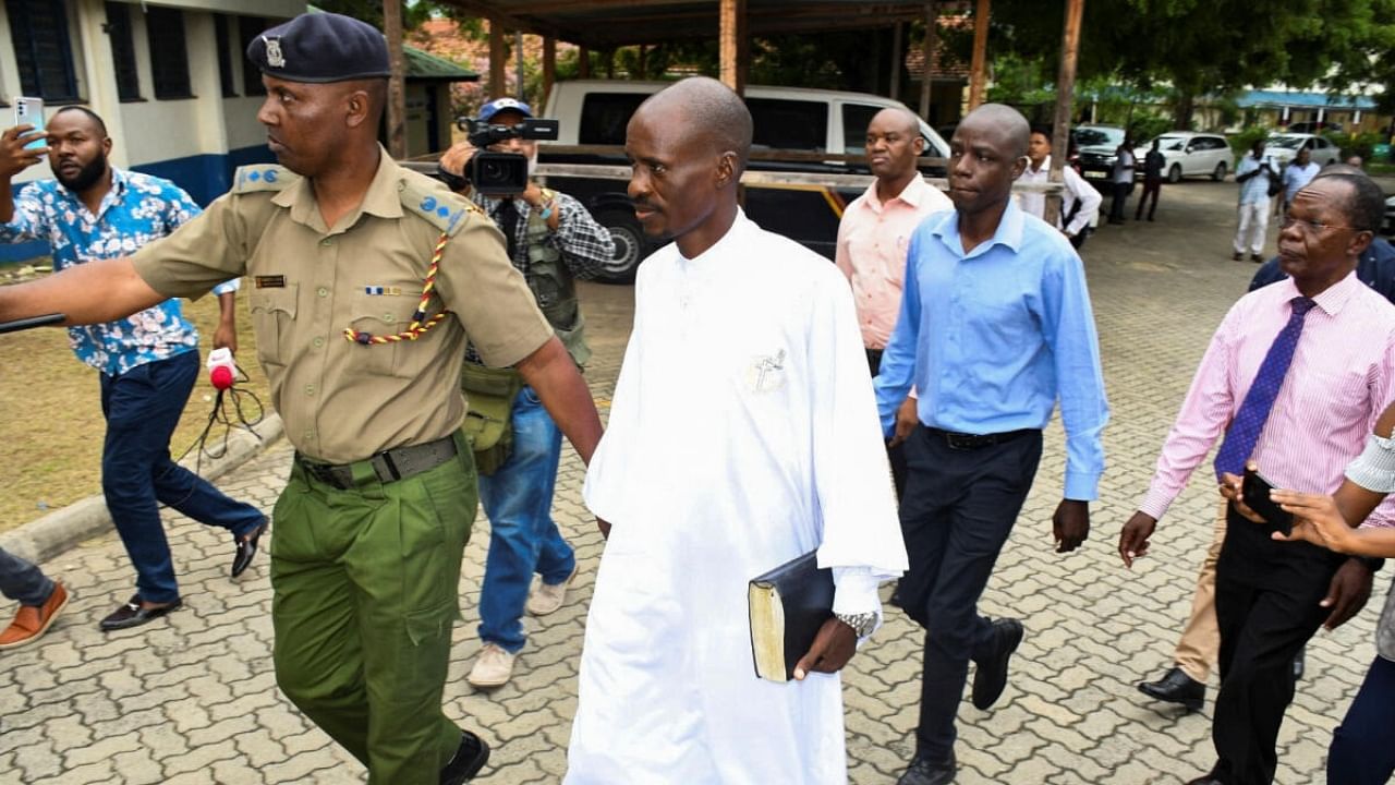 Detectives escort Ezekiel Ombok Odero, the Head of New Life Prayer Centre/Church in Kilifi County, at the police headquarters for investigations. Credit: Reuters Photo
