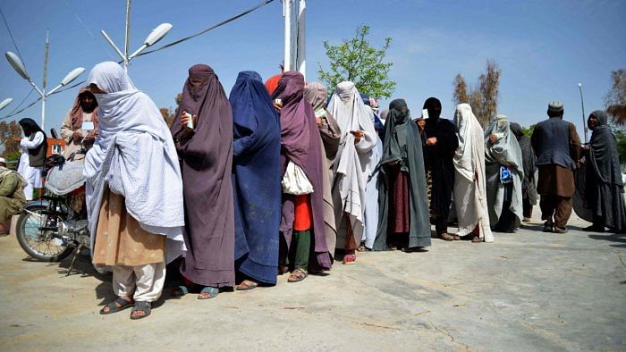 Afghan women stand on a queue to receive food aid distributed by a charity foundation during the Muslim holy fasting month of Ramadan. Credit: AFP Photo