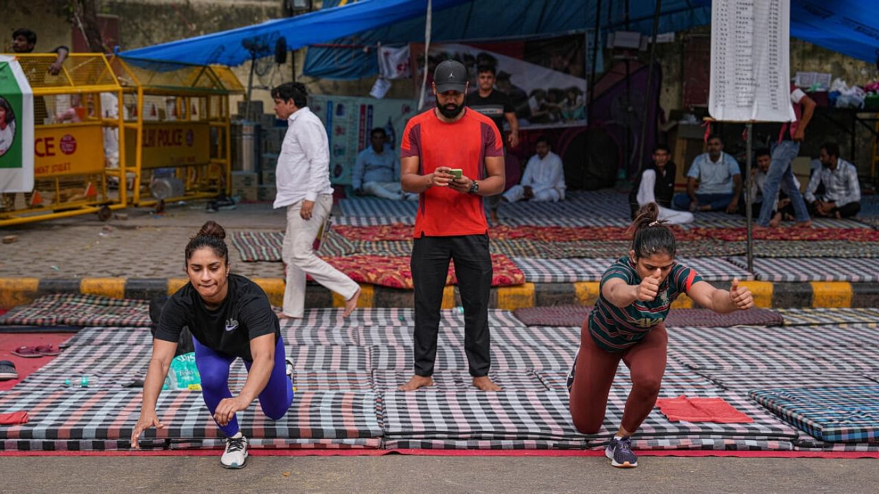 Wrestlers Vinesh Phogat and Sangita Phogat exercise at Jantar Mantar during their protest, in New Delhi. credit: PTI Photo