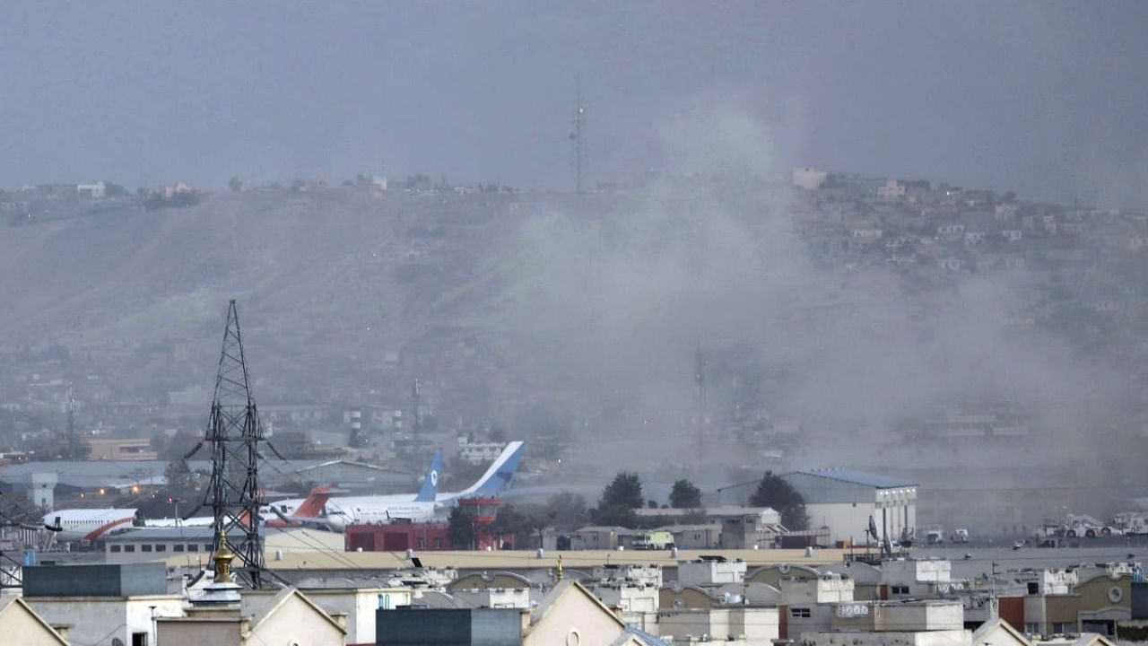 Smoke rises from a deadly explosion outside the airport in Kabul, Afghanistan, Thursday, Aug. 26, 2021. Two suicide bombers and gunmen have targeted crowds massing near the Kabul airport, in the waning days of a massive airlift that has drawn thousands of people seeking to flee the Taliban takeover of Afghanistan. Credit: AP/PTI Photo