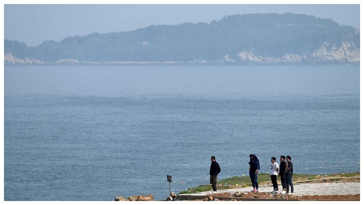 A group of men look out to the Taiwan Strait from Pingtan island, the closest point in China to Taiwan, in southeast China’s Fujian province. Credit: AFP File Photo