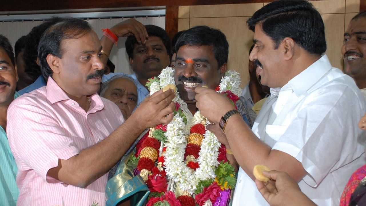 The Reddy brothers during good times. Janardhana Reddy and Karunakar Reddy offer sweets to Somashekar Reddy after the latter was elected as KMF chairman in 2011. Credit: Special Arrangement