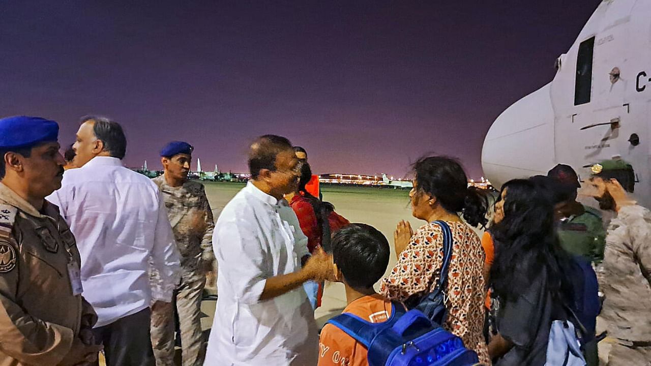  Saudi Arabia's security personnel stand to receive the 8th batch of stranded Indians in Jeddah. Credit: PTI Photo