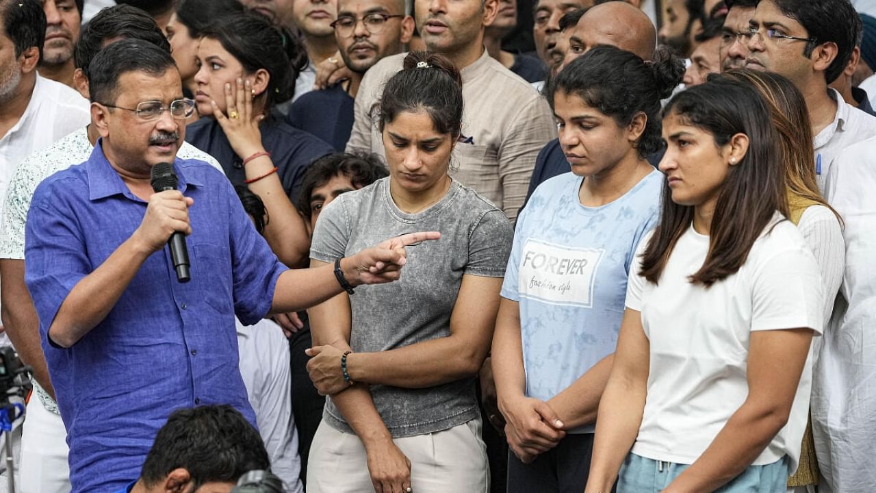 Delhi Chief Minister Arvind Kejriwal with wrestlers Vinesh Phogat, Sakshi Malik and Sangita Phogat during their protest at Jantar Mantar, in New Delhi, Saturday, April 29, 2023. Credit: PTI Photo