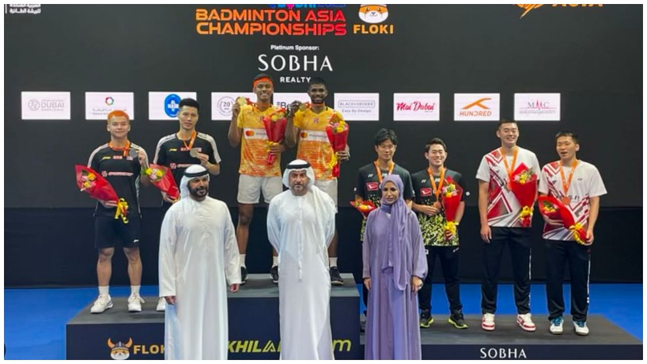 Badminton players Chirag Shetty and Satwiksairaj Rankireddy (centre) pose for photos after winning the gold medal in men's doubles at Badminton Asia Championships 2023, in Dubai, Sunday April 30, 2023. Credit: PTI Photo