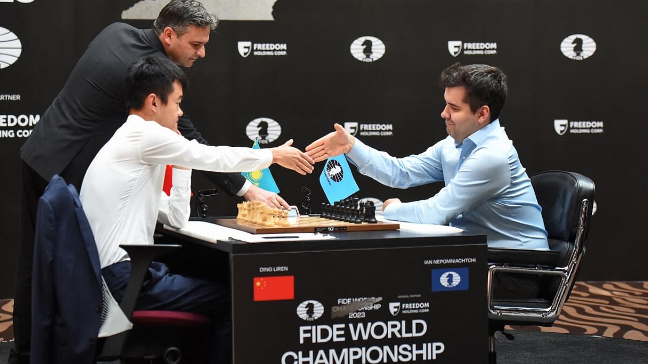 FIDE World Championship Match 2023 - Game 14 - Astana, Kazakhstan - April 29, 2023. Ding Liren of China shakes hands with Ian Nepomniachtchi of International Chess Federation. Credit: Reuters Photo