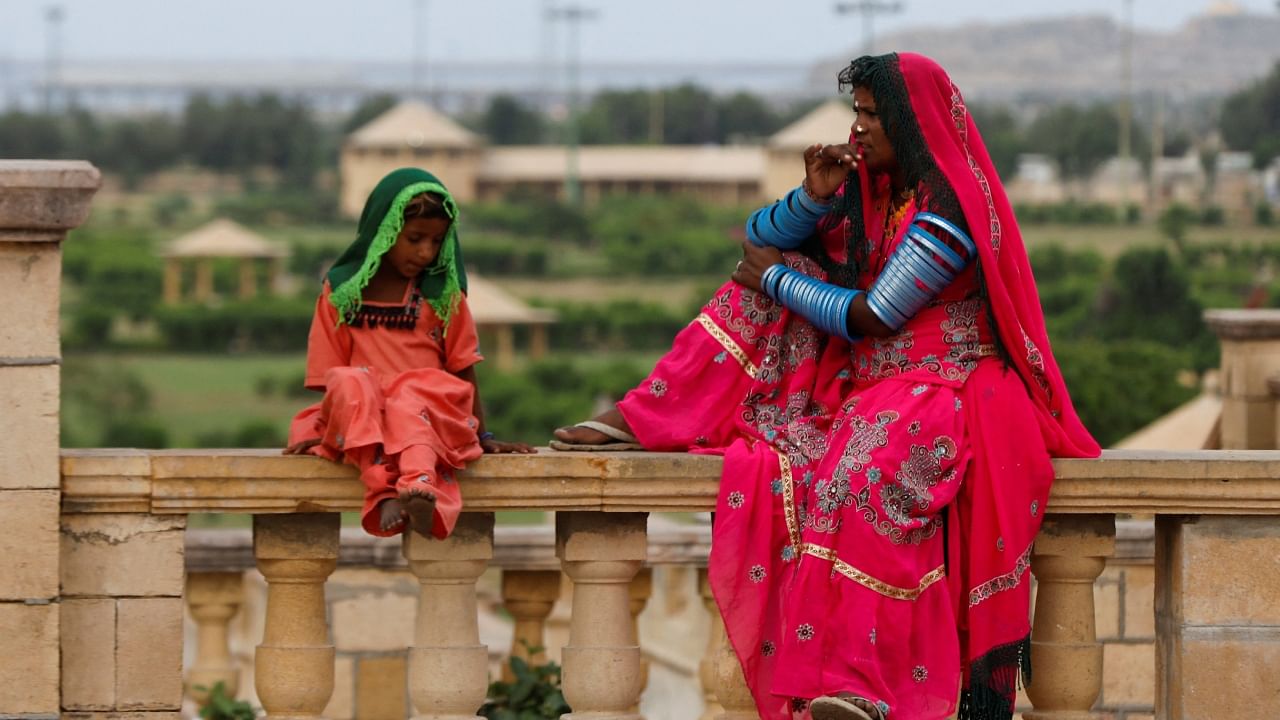 A Pakistani Hindu devotee woman and a girl sit while waiting with others for transport before leaving to pay homage at Hinglaj Mata Temple in Balochistan, outside the Shri Ratneshwar Mahadev Temple in Karachi. Credit: AFP Photo