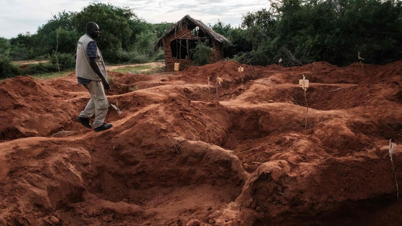 An officer of the Directorate of Criminal Investigations walks at the mass-grave site in Shakahola, outside the coastal town of Malindi. Credit: AFP Photo