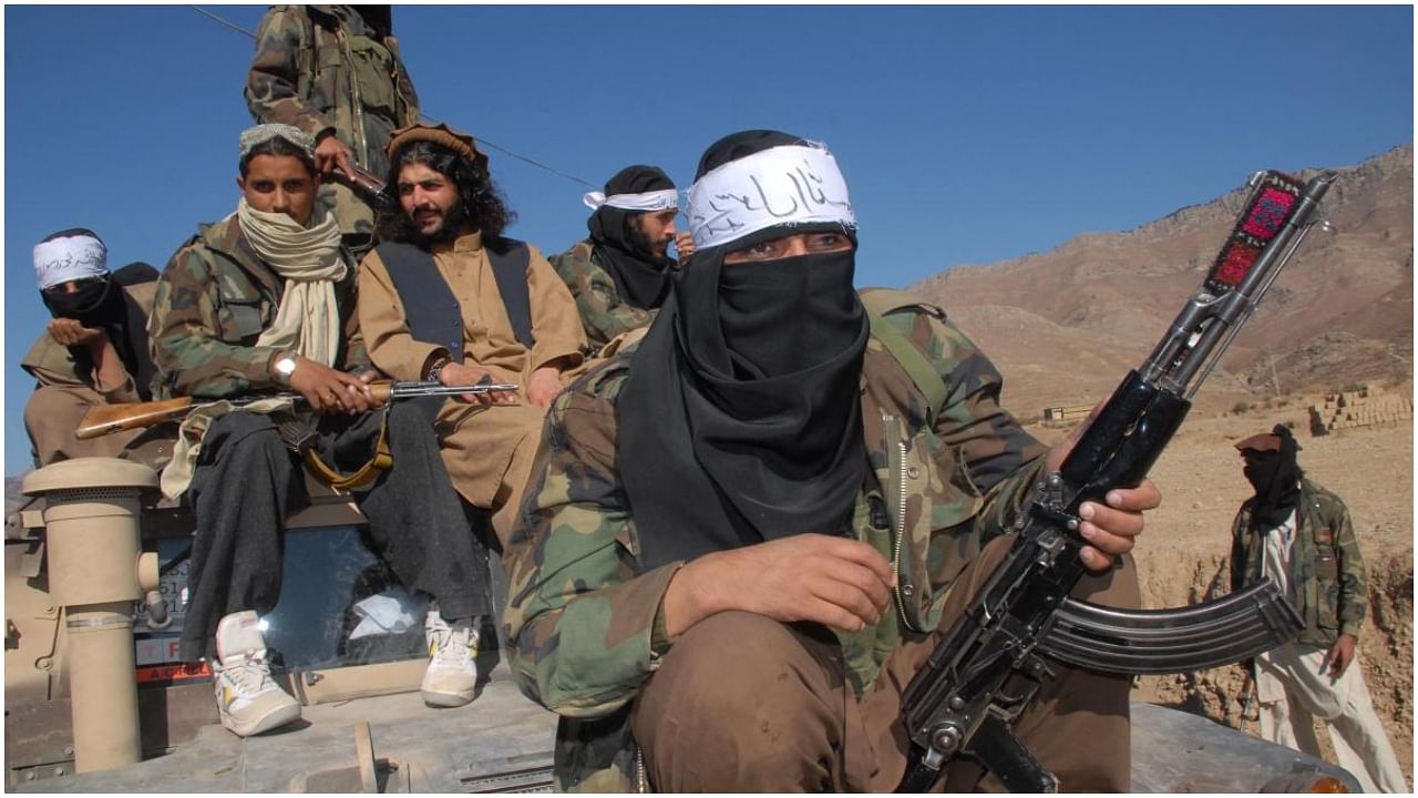 In this file photo taken on November 26, 2008, Pakistan's Taliban commander Latif Mehsud (C), a close aide to the former chief of the Tehreek-e-Taliban Pakistan (TTP), Hakimullah Mehsud, sits on a harmed vehicle in Mamouzai area of the Orakzai Agency, in Khyber Pakhtunkhwa province. Credit: AFP Photo