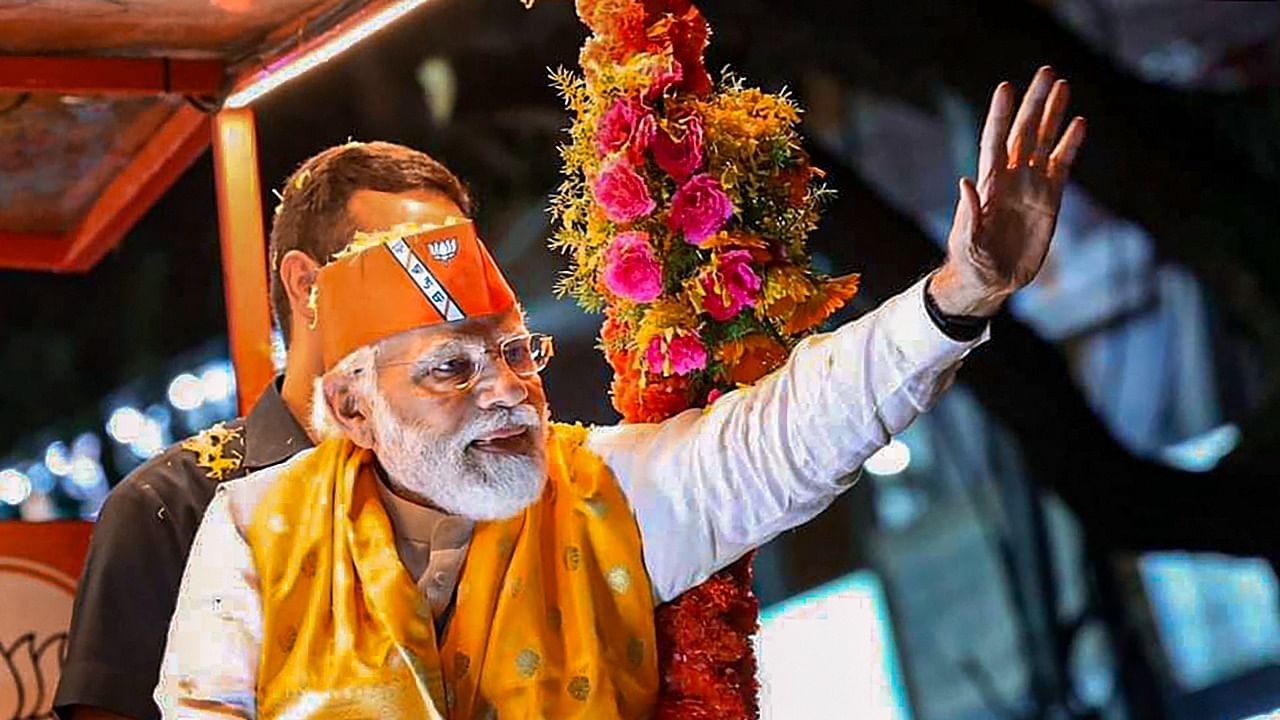  Prime Minister Narendra Modi waves at supporters during an election campaign roadshow in support of BJP candidates ahead of Karnataka Assembly polls. Credit: PTI Photo