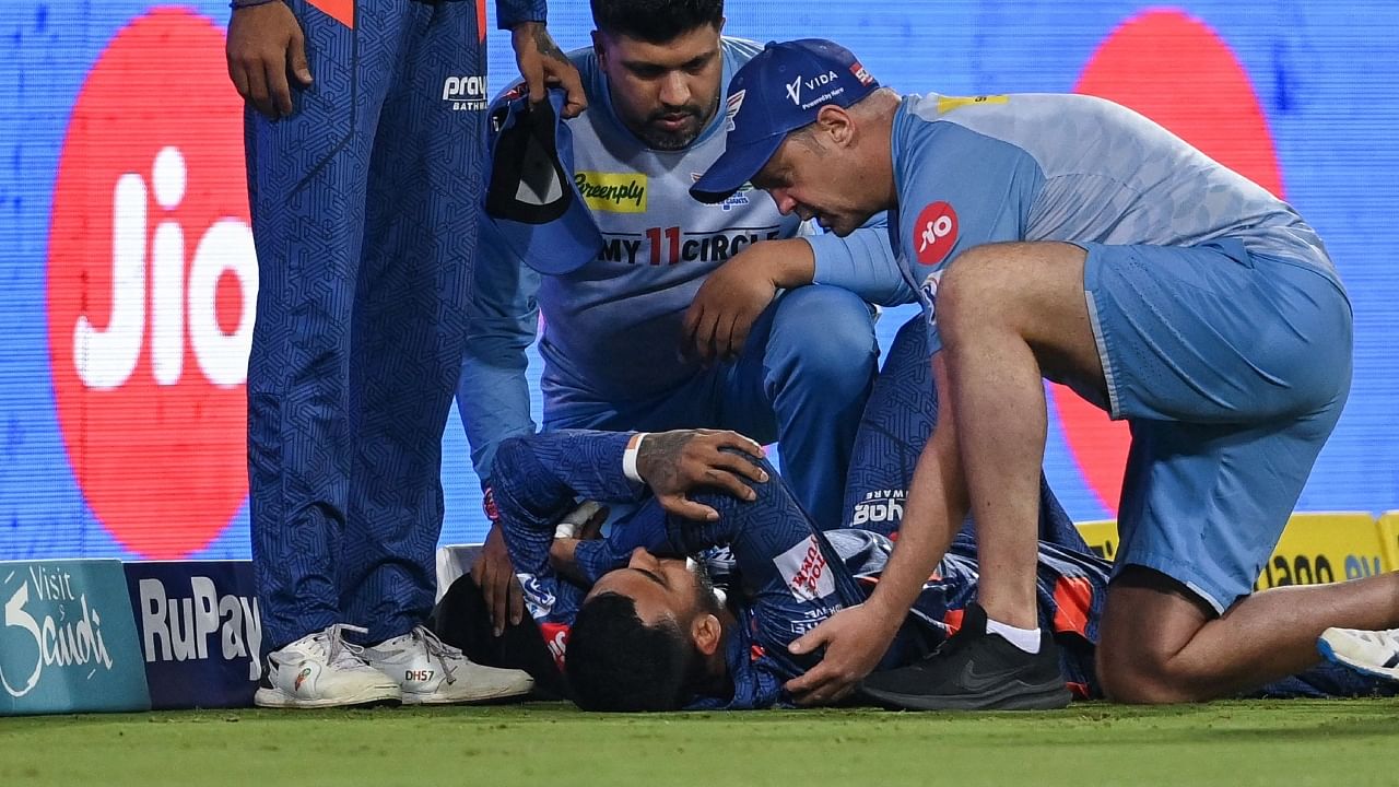 K L Rahul being helped by a medic after sustaining a thigh injury during the match against RCB, May 1, 2023. Credit: AFP Photo