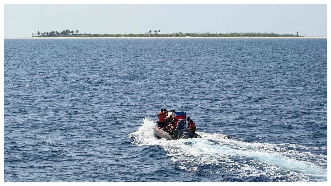 This photo taken on April 20, 2023 shows Philippine coast guard personnel onboard their rigid hull inflatable boat sailing towards the Philippine-occupied West York island in the disputed South China Sea, to bring supplies to troops. Credit: AFP Photo