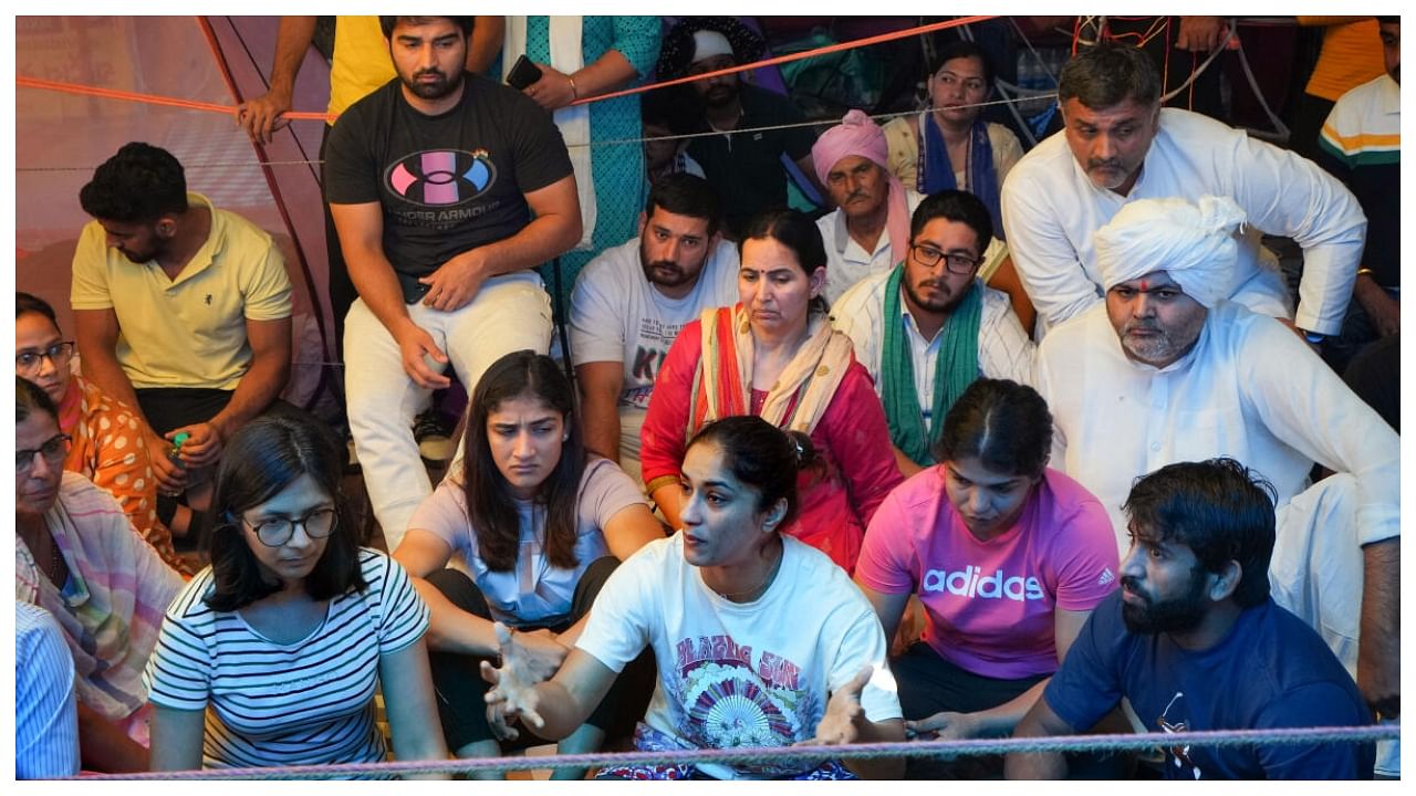 Wrestler Vinesh Phogat speaks with media as fellow wrestlers Bajrang Punia, Sakshi Malik and Sangeeta Phogat look on during their protest at Jantar Mantar, in New Delhi, Thursday. Delhi Commission for Women Chairperson Swati Maliwal is also seen. Credit: PTI Photo