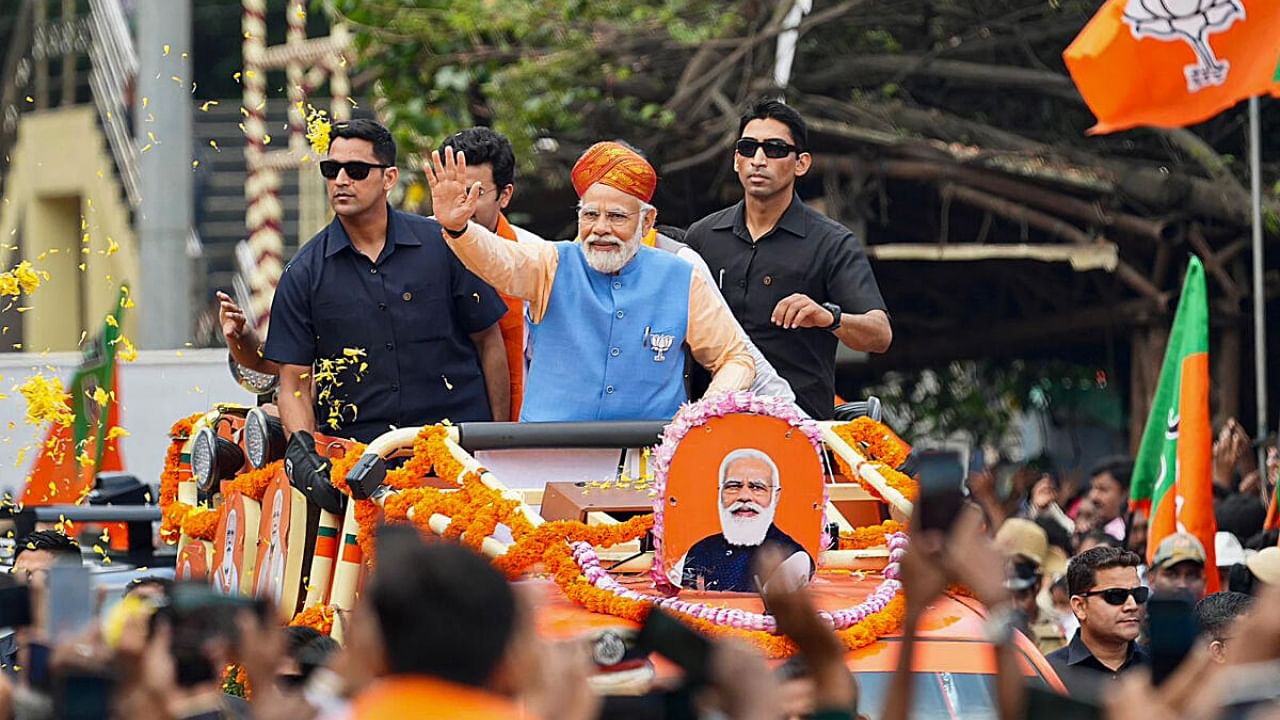 Prime Minister Narendra Modi waves at supporters during a road show ahead of Karnataka Assembly elections, in Bengaluru. Credit: PTI Photo