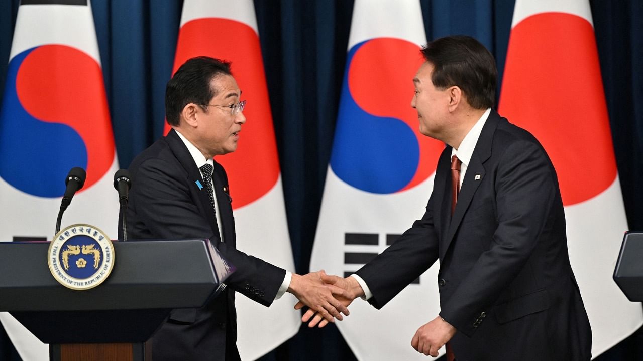South Korean President Yoon Suk Yeol shakes hands with Japanese Prime Minister Fumio Kishida. Credit: Reuters Photo