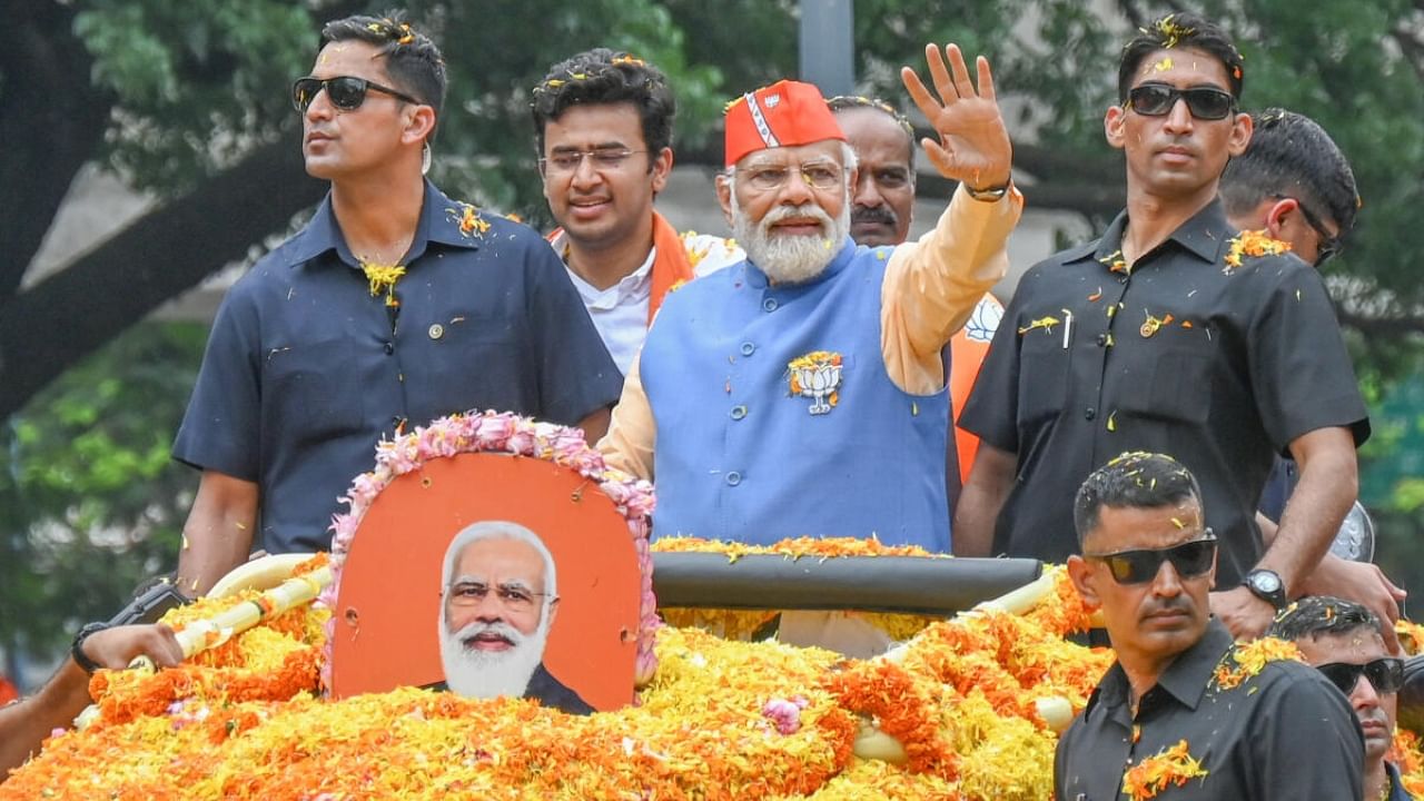 Prime Minister Narendra Modi waves to crowds during the roadshow in Bengaluru on Saturday. DH Photo/S K Dinesh