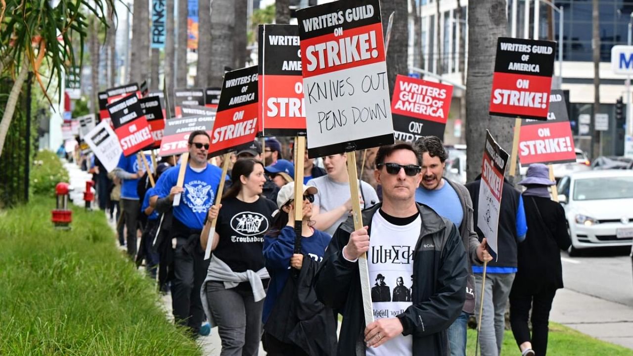 Writer Eric Heisserer hold his sign on the picket line on the fourth day of the strike by the Writers Guild of America in front of Netflix in Hollywood, California, on May 5, 2023. Credit: AFP Photo