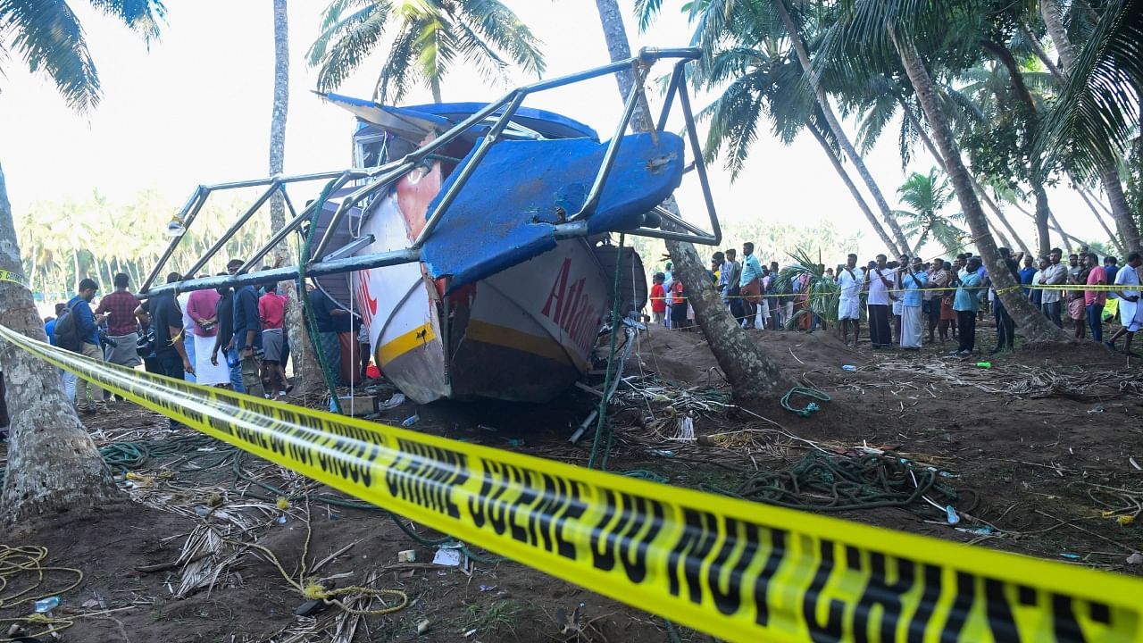 People look at the tourist boat that capsized May 7 night in Malappuram, Kerala, Monday, May 8, 2023. Credit: PTI Photo