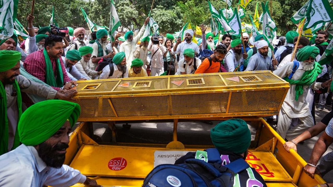  Farmers break police barricade as they arrive to join wrestlers protesting at Jantar Mantar, in New Delhi. Credit: PTI Photo