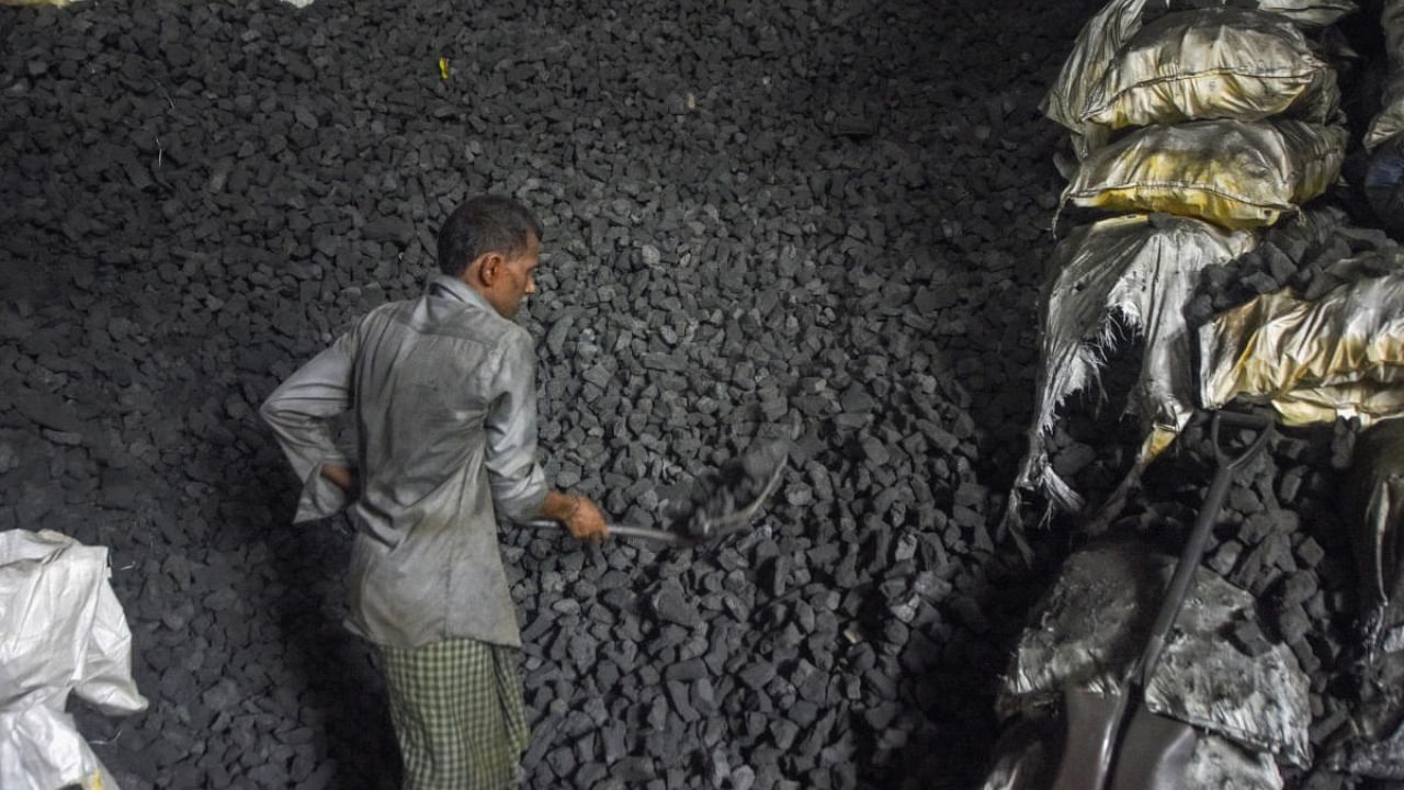 A worker loads coal into a sack at a coal wholesale market in Mumbai, Monday, May 9, 2022. Credit: PTI Photo