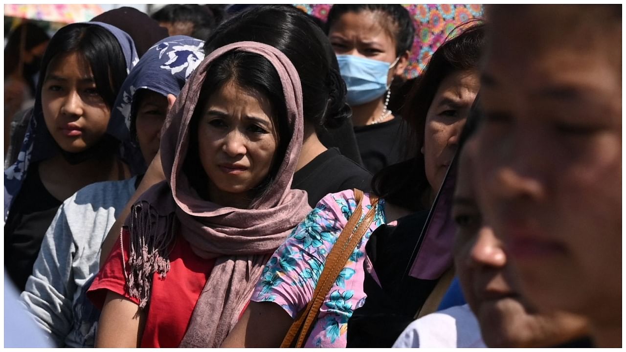 People queue up for a food distribution by the Indian army at Imphal airport on May 7, 2023, as they flee ethnic violence. Credit: AFP Photo