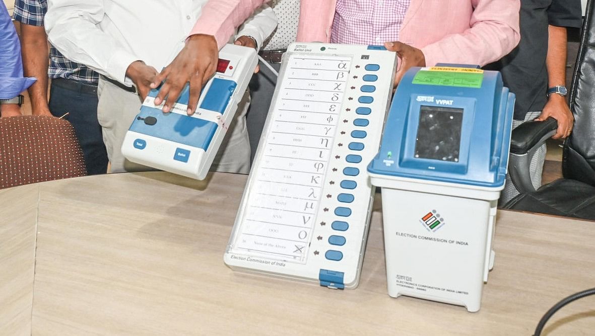 Polling officers showcasing EVM and VVPAT to media. Credit: DH Photo/ S K Dinesh