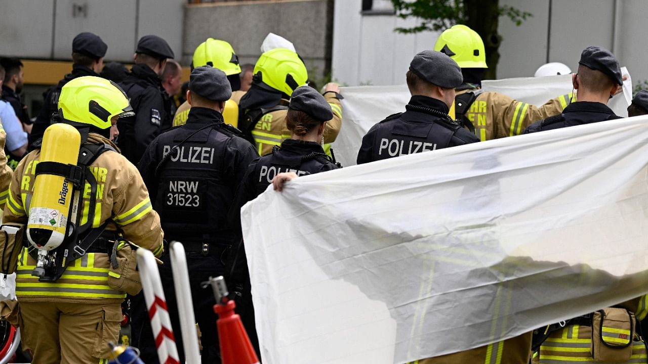 Shielded by paramedics, an injured person is brought to an ambulance close to the site of an explosion on May 11, 2023 in Ratingen, western Germany. Credit: AFP Photo