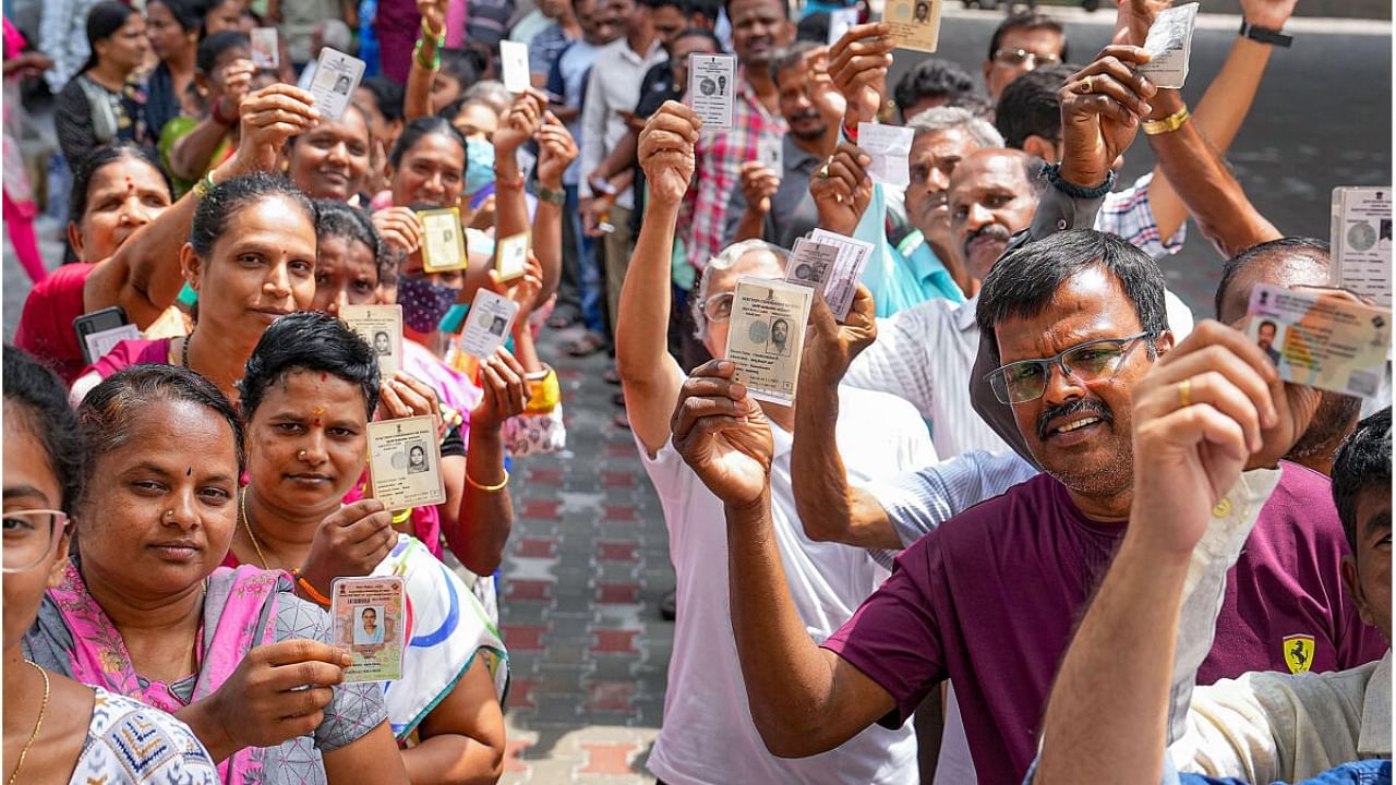 People wait in queues at a polling station to cast their votes in Assembly elections in Bengaluru on Wednesday. Credit: PTI Photo